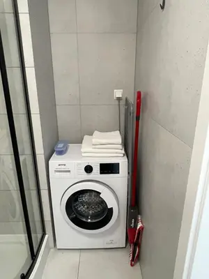 a small room with a washing machine in a bathroom at Old Town Escape in Kraków