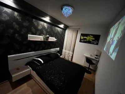 a black couch in a room with a black wall at Apartment with living room, kitchen, bedroom, bathroom in amazing neighborhood in Kraków