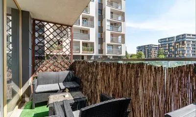 a balcony with chairs and a fence and a building at Apartment with living room, kitchen, bedroom, bathroom in amazing neighborhood in Kraków