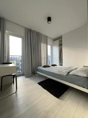 a bedroom with a large bed and a desk at Zabłocie Luxury Apartment WAWELOFTS in Kraków