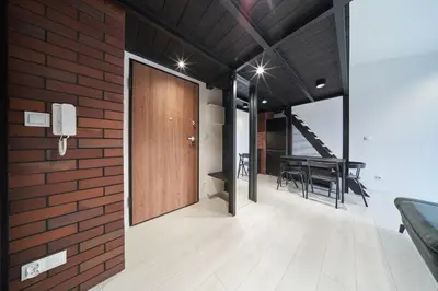 a brick wall with a wooden door and a table at Zabłocie Luxury Apartment WAWELOFTS in Kraków