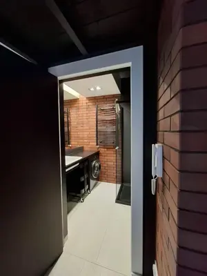 an open door leading to a bathroom with a sink at Zabłocie Luxury Apartment WAWELOFTS in Kraków