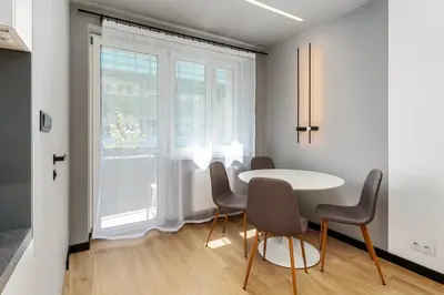 a dining room with a table and chairs and a window at Topolowa Modern Studio by BookingHost in Kraków