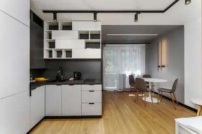 a kitchen with white cabinets and a table with chairs at Topolowa Modern Studio by BookingHost in Kraków