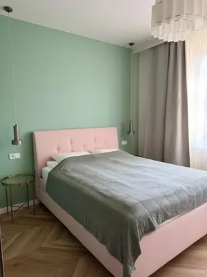 a bedroom with a pink bed and a window at Olszańska Gem in Kraków