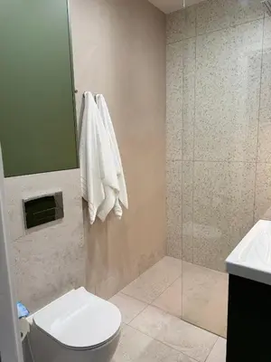 a bathroom with a shower and a toilet and a sink at Olszańska Gem in Kraków