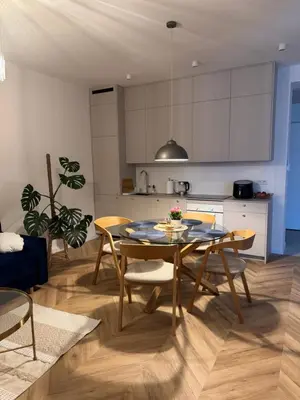 a kitchen and dining room with a table and chairs at Olszańska Gem in Kraków