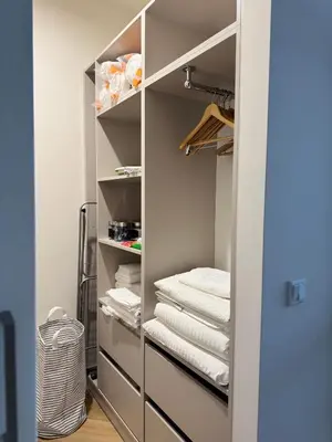 a walk in closet with white towels on shelves at Olszańska Gem in Kraków