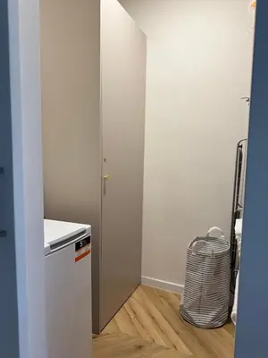 a small kitchen with white walls and a refrigerator at Olszańska Gem in Kraków