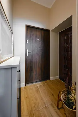 a large wooden door in a room with wooden floors at UR4N Apartment - Konarskiego in Kraków