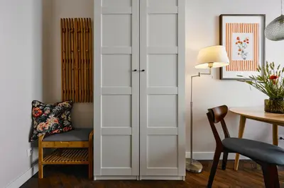 a room with white doors and a chair and a table at UR4N Apartment - Konarskiego in Kraków