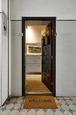 a door leading into a hallway with a welcome mat at UR4N Apartment - Konarskiego in Kraków