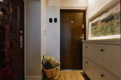 a hallway with a door and a plant in a basket at UR4N Apartment - Konarskiego in Kraków