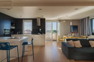 a living room and kitchen with a couch and a table at Białoprądnicka - Stay&Park in Kraków