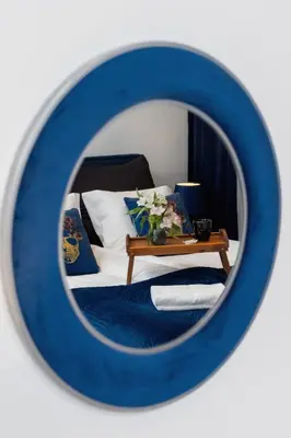 a mirror reflecting a bedroom with a bed and a table at Studio Cracow Starowiślna by Noclegi Renters in Kraków