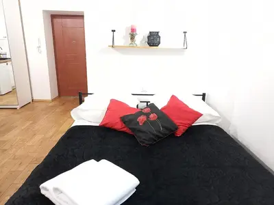 a bedroom with a bed with red and black pillows at Old Town Apt - Lubicz 2b in Kraków