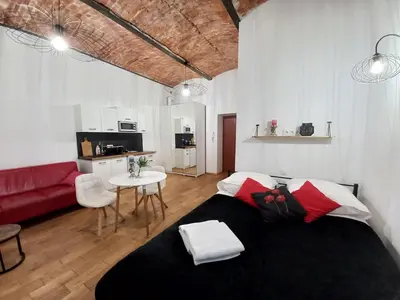a living room with a bed and a red couch at Old Town Apt - Lubicz 2b in Kraków