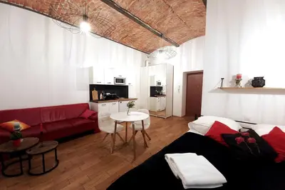 a living room with a red couch and a table at Old Town Apt - Lubicz 2b in Kraków