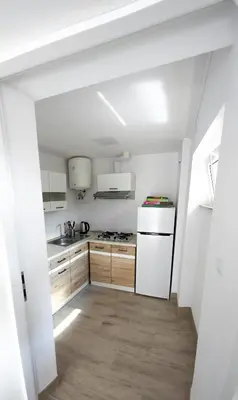 a kitchen with white appliances and wooden cabinets at Jurajska47 in Wola Kalinowska
