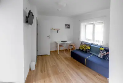 a living room with a blue couch and a table at Jurajska47 in Wola Kalinowska