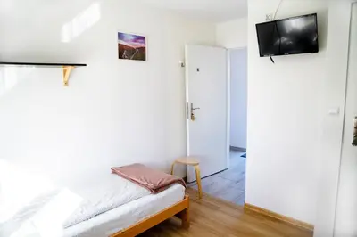 a bedroom with a bed and a tv on a wall at Jurajska47 in Wola Kalinowska