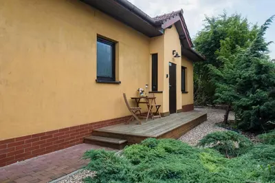 a house with a wooden porch with a table on it at Carlson near Enerdgylandia in Zator