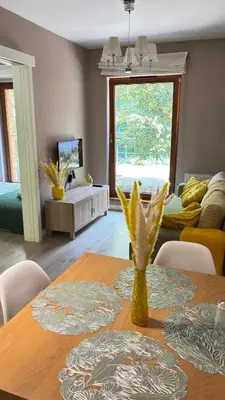 a dining room with a table and a living room at Cozy Mood Apartment Cracow in Kraków