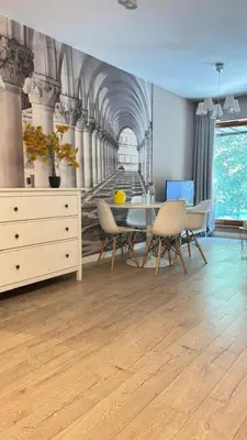 a dining room with a table and chairs and a tunnel mural at Cozy Mood Apartment Cracow in Kraków