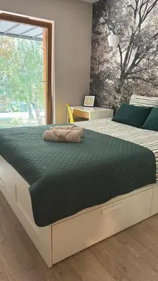 a large bed in a bedroom with a large window at Cozy Mood Apartment Cracow in Kraków