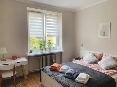 a bedroom with a bed and a window with towels at Apartament Marysia in Oświęcim
