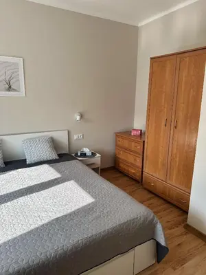 a bedroom with a bed and a wooden cabinet at Apartament Marysia in Oświęcim