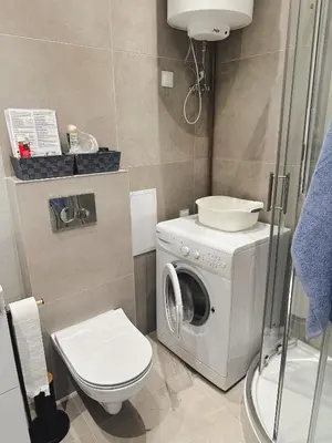a bathroom with a washing machine and a toilet at Apartament Marysia in Oświęcim