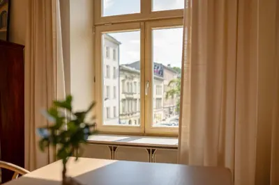 a room with a window with a table and a plant at Wolnica No 11 Residence in Kraków