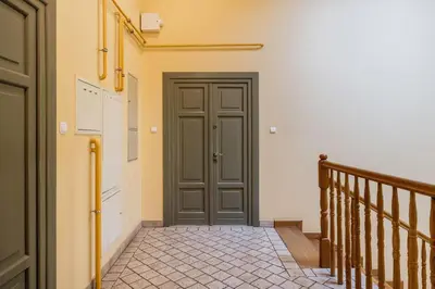 a hallway with a door and a staircase with a stair case at Wolnica No 11 Residence in Kraków