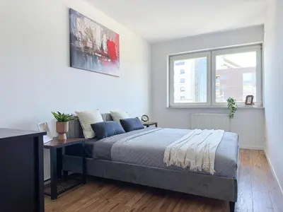 a bedroom with a bed and a window at Krakowska Konstelacja Apartament premium in Kraków