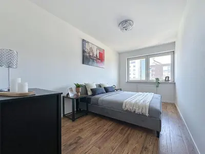 a bedroom with a bed and a table in it at Krakowska Konstelacja Apartament premium in Kraków