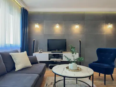 a living room with a couch and a tv at Krakowska Konstelacja Apartament premium in Kraków