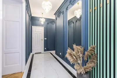 a hallway with blue walls and chandeliers at BoB Elite - Floriańska in Kraków
