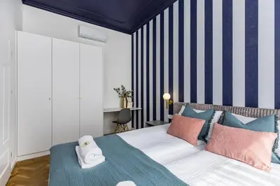 a bedroom with a bed and a striped wall at BoB Elite - Floriańska in Kraków