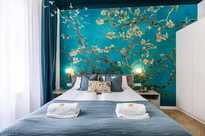 a bedroom with a blue wall with a tree mural at BoB Elite - Floriańska in Kraków