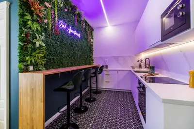 a bar with a green wall with plants at BoB Elite - Floriańska in Kraków