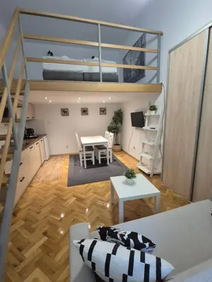 a living room with a table and a loft bed at Silent Garncarska Apartment in Kraków