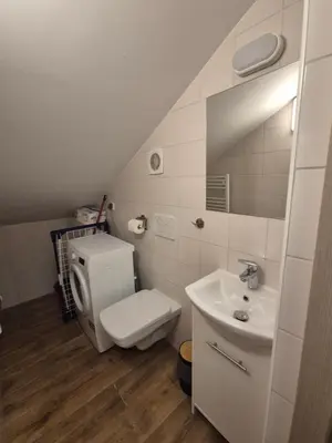 a white bathroom with a toilet and a sink at Silent Garncarska Apartment in Kraków