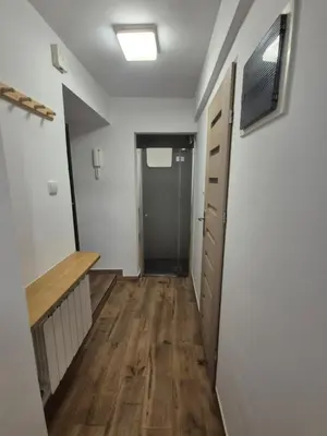 a hallway of an apartment with a door and wooden floors at Silent Garncarska Apartment in Kraków