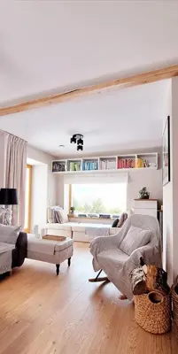 a white living room with a couch and a chair at Spokojnia Dom Wiejski in Zawoja