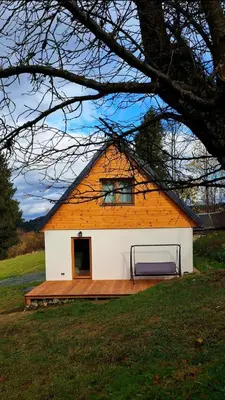 a large building with a wooden deck in front of it at Spokojnia Dom Wiejski in Zawoja