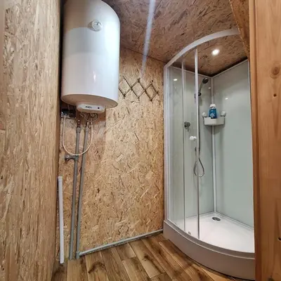 a bathroom with a shower with a glass door at Przytulny domek na skraju lasu in Tabaszowa