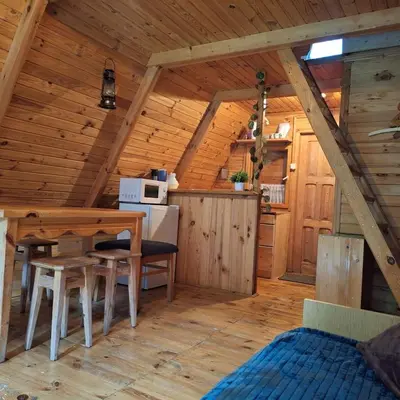 a kitchen and dining room in a log cabin at Przytulny domek na skraju lasu in Tabaszowa