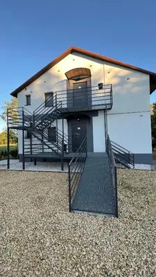 a building with a staircase in front of it at Aparthotel w Dolinie Stawów Zator in Zator