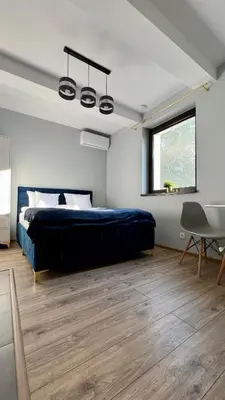 a bedroom with a bed and a table and a window at Aparthotel w Dolinie Stawów Zator in Zator